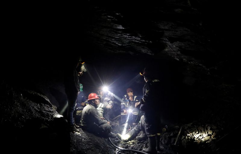 &copy; Reuters. FILE PHOTO: Men who work as miners talk to each other as they sit inside a gold mine in La Rinconada, the Andes, Peru, October 9, 2019. REUTERS/Nacho Doce   