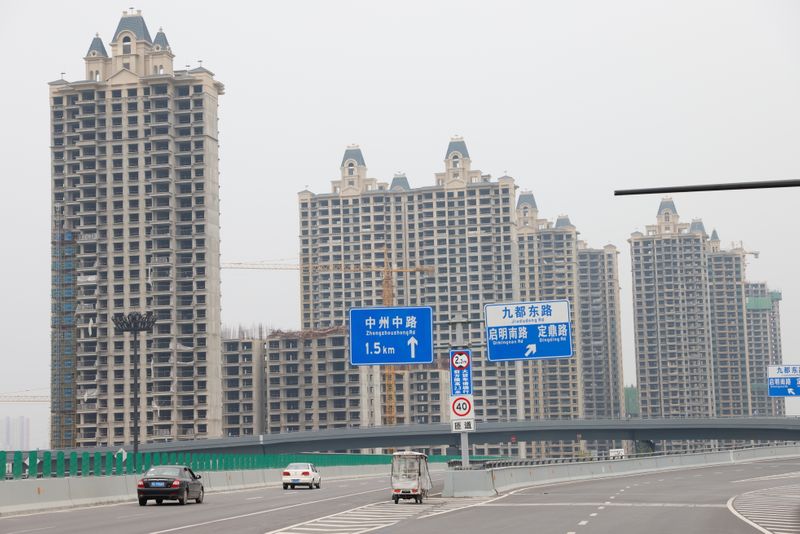 &copy; Reuters. FOTO DE ARCHIVO: Vehículos pasan junto a edificios residenciales inacabados del Oasis de Evergrande, un complejo de viviendas desarrollado por el Grupo Evergrande, en Luoyang, China el 16 de septiembre de 2021. Imagen tomada el 16 de septiembre de 2021. 