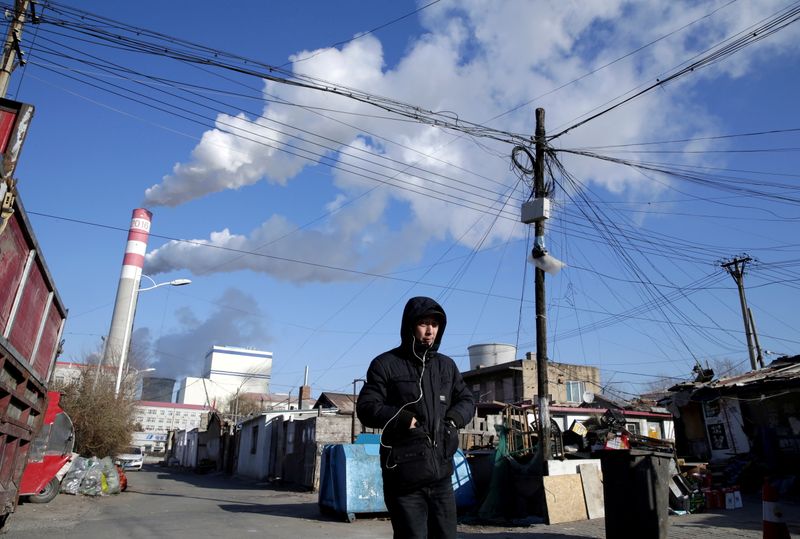 &copy; Reuters. FOTO DE ARCHIVO: Un hombre camina cerca de una central eléctrica de carbón en Harbin, provincia de Heilongjiang, China 27 de noviembre de 2019. REUTERS/Jason Lee