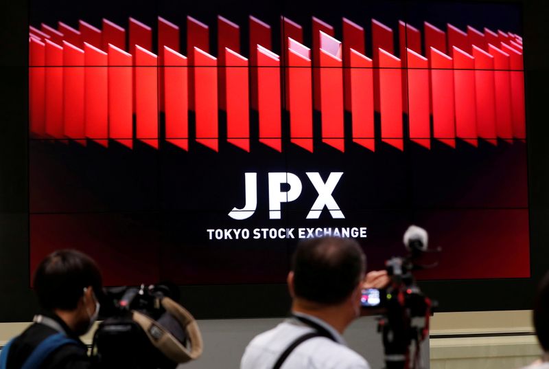 &copy; Reuters. FILE PHOTO: TV camera men wait for the opening of market in front of a large screen showing stock prices at the Tokyo Stock Exchange in Tokyo, Japan October 2, 2020. REUTERS/Kim Kyung-Hoon/File Photo
