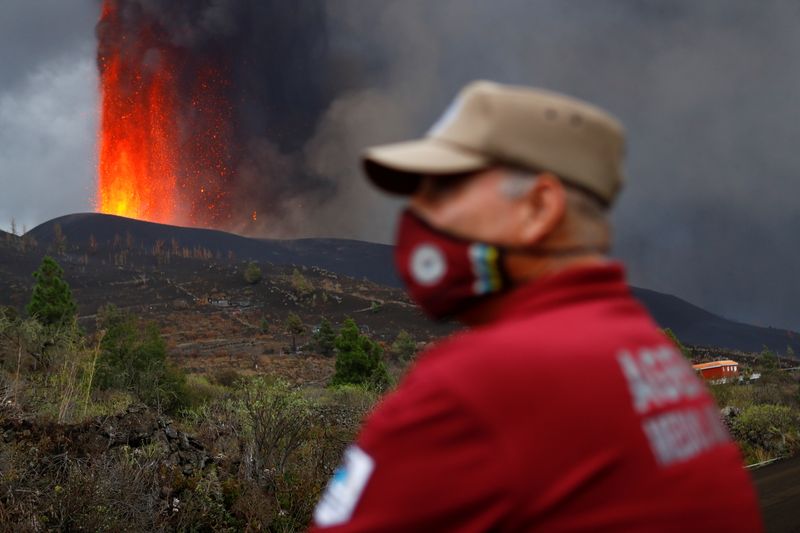 © Reuters. An environmental agent looks on as lava rises following the eruption of a volcano on the Island of La Palma, in Tacande, Spain September 22, 2021. REUTERS/Borja Suarez