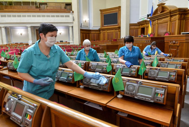 &copy; Reuters. FOTO DE ARCHIVO: Un grupo de trabajadoras desinfecta los escaños de los legisladores ucranianos en la sala de sesiones del Parlamento nacional en Kiev, Ucrania, el 19 de marzo de 2020. REUTERS/Stringer