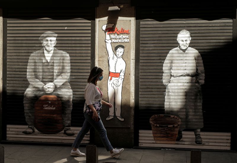 &copy; Reuters. FILE PHOTO: A woman wearing a protective mask walks past a closed restaurant, amid the coronavirus disease (COVID-19) outbreak, in Madrid, Spain, July 31, 2020. REUTERS/Javier Barbancho