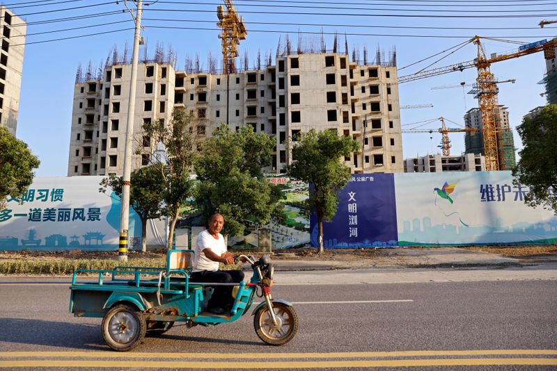 &copy; Reuters. A man rides a vehicle past the construction site of Evergrande Cultural Tourism City, a project developed by China Evergrande Group, in Suzhou's Taicang, Jiangsu province, China September 23, 2021. REUTERS/Aly Song