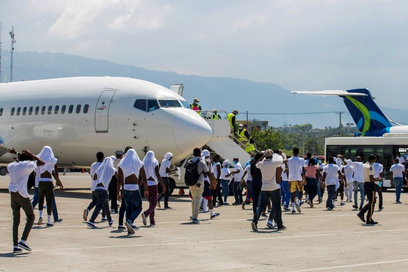 &copy; Reuters. FILE PHOTO: Haitian migrants board an airport bus aftter U.S. authorities flew them out of a Texas border city after crossing the Rio Grande river from Mexico, at Toussaint Louverture International Airport in Port-au-Prince, Haiti September 21, 2021. REUT
