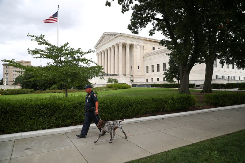 &copy; Reuters. FILE PHOTO: A U.S. Capitol Police Officer walks with a dog near the U.S. Supreme Court in Washington, U.S., September 1, 2021. REUTERS/Tom Brenner/File Photo