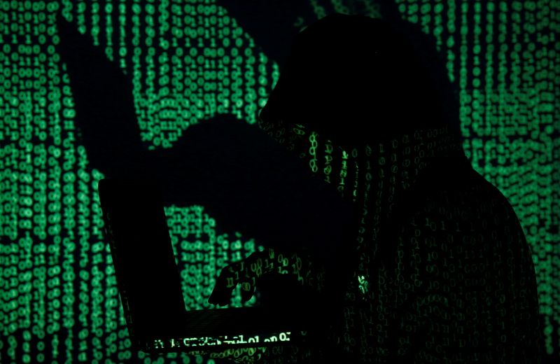 &copy; Reuters. FILE PHOTO: A man holds a laptop computer as cyber code is projected on him in this illustration picture taken on May 13, 2017. REUTERS/Kacper Pempel/Illustration/File Photo