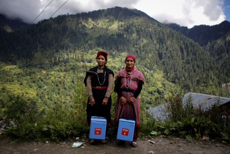 &copy; Reuters. Nirma Devi, 31, and Phula Devi, 30, hold boxes containing COVISHIELD vaccines as they pose for a picture at Malana village in Kullu district in the Himalayan state of Himachal Pradesh, India, September 14, 2021. Despite the hostile terrain, the northern s