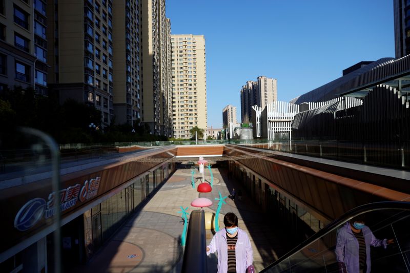 &copy; Reuters. FILE PHOTO: A woman rides an escalator at an Evergrande Plaza shopping mall in a residential compound developed by China Evergrande Group in Beijing, China September 22, 2021. REUTERS/Carlos Garcia Rawlins