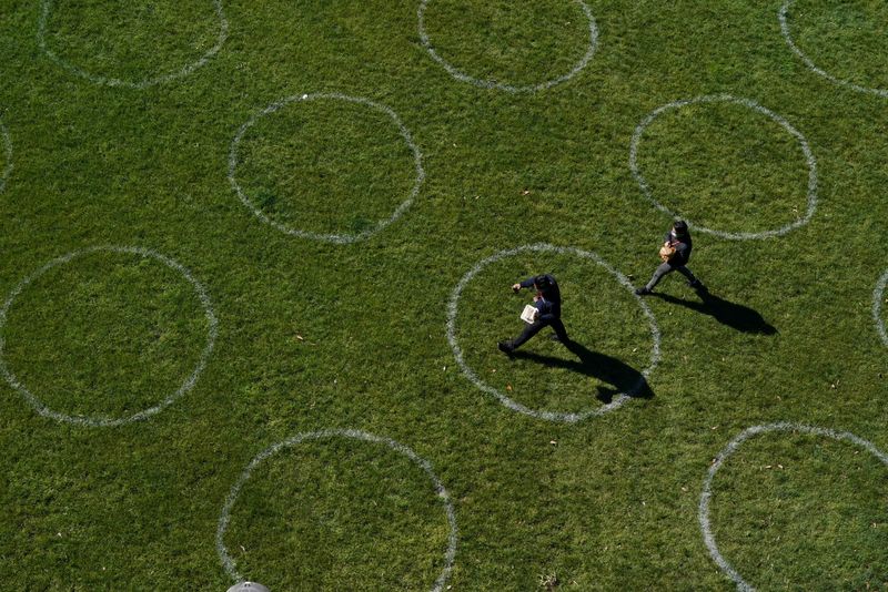 &copy; Reuters. People walk through a city park marked with social distancing circles as some restrictions are eased for fully-vaccinated residents during a lockdown to curb the spread of a coronavirus disease (COVID-19) outbreak in Sydney, Australia, September 22, 2021.