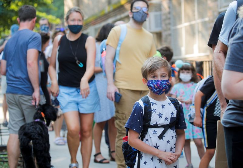 &copy; Reuters.   ９月２２日、米国で新型コロナウイルスから子どもたちを守りたいと切望していた多くの親にとって朗報が舞い込んだ。写真は１３日、学校に投稿する児童ら。ニューヨーク市ブルックリ