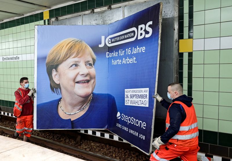 &copy; Reuters. Workers remove an advertisement showing German Chancellor Angela Merkel with a slogan that reads "Mother of Nation - Thanks For 16 Years of Hard Work" before the upcoming state elections in Hamburg, Germany September 24, 2021. REUTERS/Fabian Bimmer 