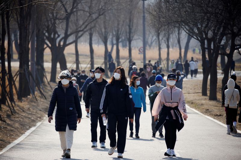 &copy; Reuters. FOTO DE ARCHIVO: Personas con mascarillas dan un paseo en medio de la pandemia de la enfermedad del coronavirus (COVID-19) en un parque de Hanriver en Seúl, Corea del Sur, 21 de febrero de 2021. REUTERS/Kim Hong-Ji