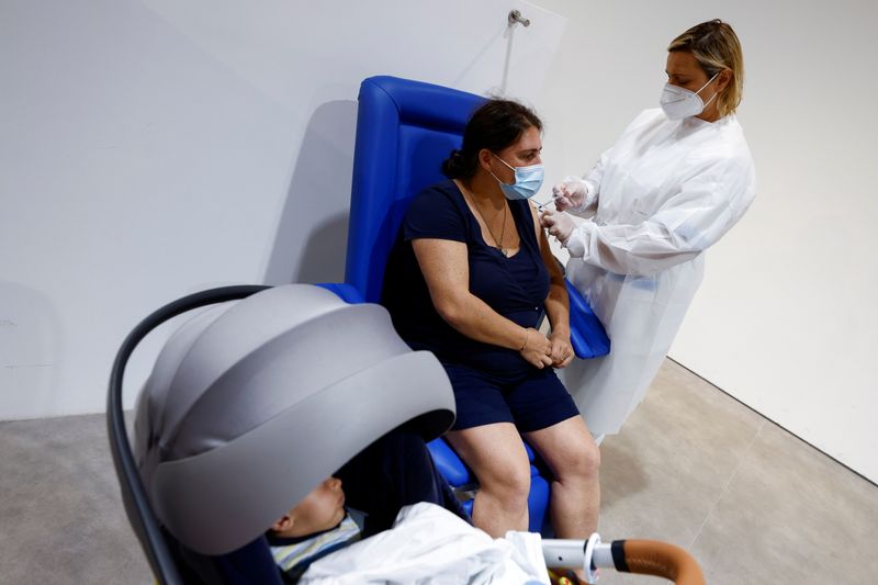 &copy; Reuters. FILE PHOTO: A woman receives a dose of the Moderna vaccine against the coronavirus disease (COVID-19) at the Music Auditorium in Rome, Italy, August 5, 2021. REUTERS/Guglielmo Mangiapane