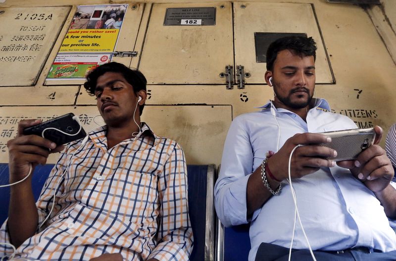 &copy; Reuters. FILE PHOTO: Commuters watch videos on their mobile phones as they travel in a suburban train in Mumbai, India, April 2, 2016.  Picture taken April 2, 2016. REUTERS/Shailesh Andrade