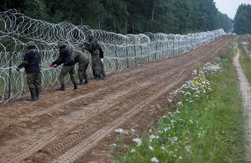 © Reuters. Des soldats polonais construisent une clôture à la frontière avec la Biélorussie, près du village de Nomiki. L'Union européenne a demandé vendredi à la Pologne d'autoriser des représentants de Frontex à se rendre à sa frontière avec la Biélorussie, alors que le pays est aux prises avec une vague d'immigration clandestine, que le bloc impute à Minsk. /Photo prise le 26 aôut 2021/REUTERS/Kacper Pempel
