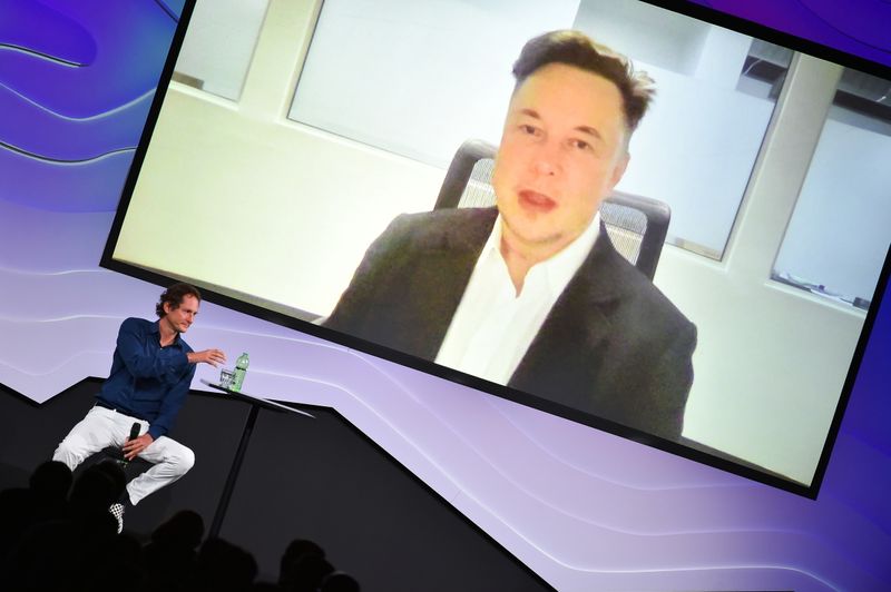 © Reuters. Chairman of Stellantis and Ferrari John Elkann speaks via video conference with Tesla's founder Elon Musk during the 
