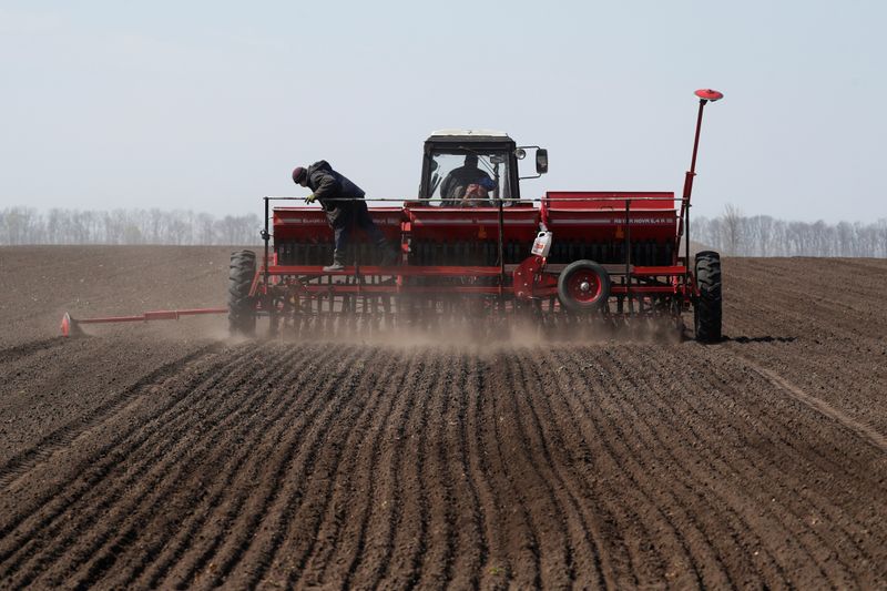 © Reuters. Imagen de archivo de un trabajador agrícola controlando una máquina sembradora durante la siembra de soja cerca del pueblo de Husachivka en la región de Kiev, Ucrania. 17 de abril, 2020. REUTERS/Valentyn Ogirenko/Archivo