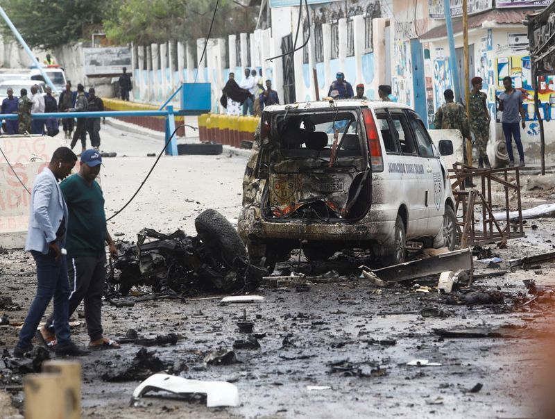 &copy; Reuters. Civilians and Somalian security officers gather at the scene of a suicide car bomb at a street junction near the president's residence, in Mogadishu, Somalia, September 25, 2021. REUTERS/Feisal Omar