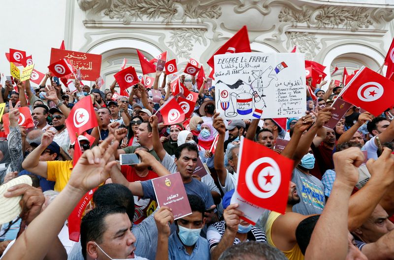 &copy; Reuters. متظاهرون يرفعون أعلاما ولافتات خلال احتجاج ضد تولي الرئيس قيس سعيد مقاليد الحكم في العاصمة التونسية يوم الأحد. تصوير: زبير السويسي - رويترز.
