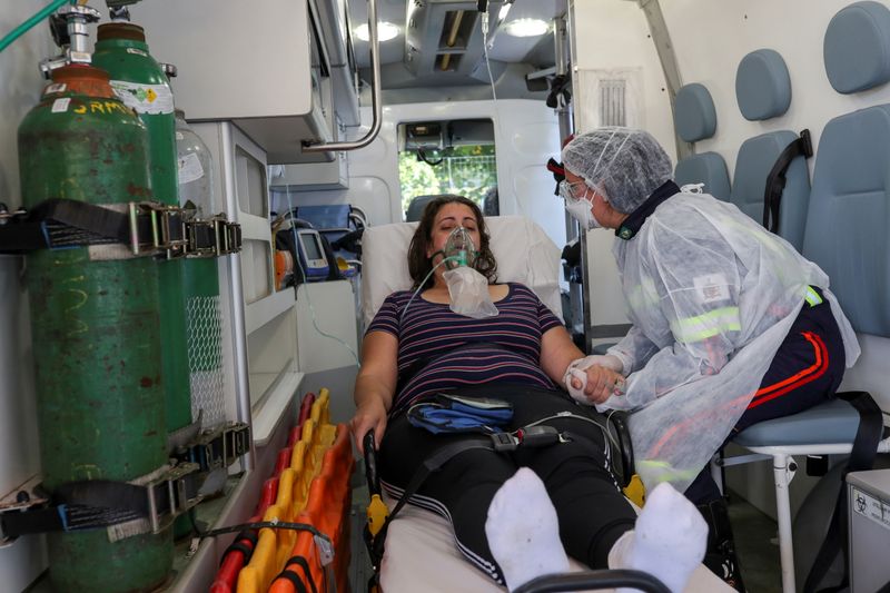 &copy; Reuters. FOTO DE ARCHIVO: La enfermera Danila Bassi, miembro de un equipo del Servicio de Atención Móvil de Urgencia (SAMU), sostiene la mano de Marley das Gracas, de 42 años, que dio positivo a la enfermedad del coronavirus (COVID-19), dentro de una ambulancia