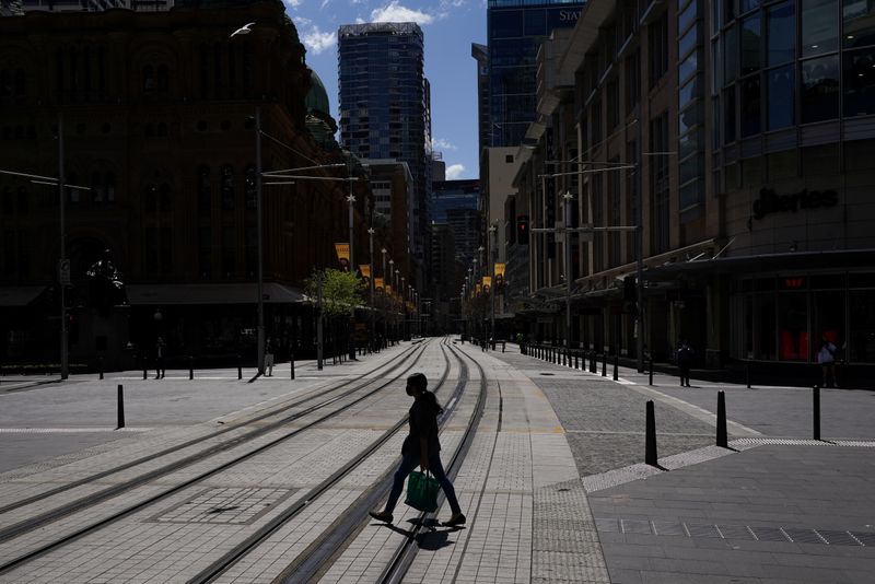 &copy; Reuters. FILE PHOTO: A pedestrian wearing a protective face mask crosses tram lines in the city centre during a lockdown to curb the spread of a coronavirus disease (COVID-19) outbreak in Sydney, Australia, September 24, 2021.  REUTERS/Loren Elliott