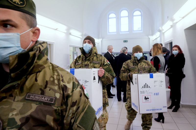 &copy; Reuters. FILE PHOTO: Hungarian soldiers carry the first shipment of Pfizer-BioNTech coronavirus disease (COVID-19) vaccines at the Del-Pest Central Hospital in Budapest, Hungary, December 26, 2020. Szilard Koszticsak/Pool via REUTERS/File Photo