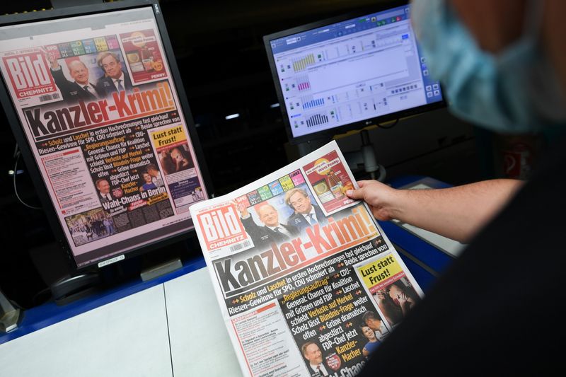 &copy; Reuters. A worker checks a printed edition of Bild newspaper that shows candidates for chancellor Olaf Scholz, of Social Democratic Party (SPD), and Armin Laschet, of Christian Democratic Union (CDU), after the first exit polls for the general elections in Berlin,