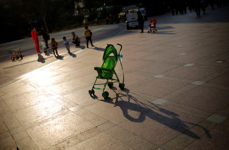 &copy; Reuters. FOTO DE ARCHIVO: Un cochecito de bebé es visto mientras las madres juegan con sus hijos en una zona pública en el centro de Shanghai el 19 de noviembre, 2013. REUTERS/Carlos Barria/File Photo