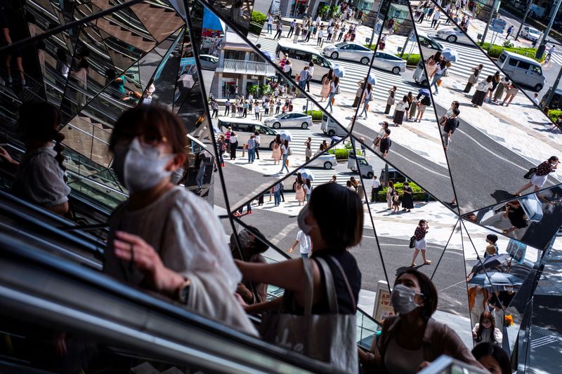 © Reuters. FILE PHOTO: People wearing protective masks are reflected in the mirror at a shopping mall in Tokyo amid the coronavirus disease (COVID-19) outbreak in Tokyo, Japan, August 19, 2021. REUTERS/Athit Perawongmetha/File Photo