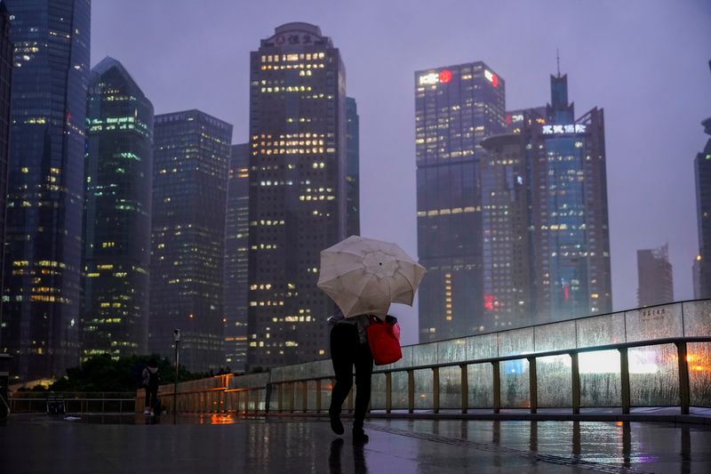 &copy; Reuters. A woman walks with an umbrella amid rainfall, as Typhoon Chanthu approaches, in Shanghai, China September 13, 2021. REUTERS/Aly Song