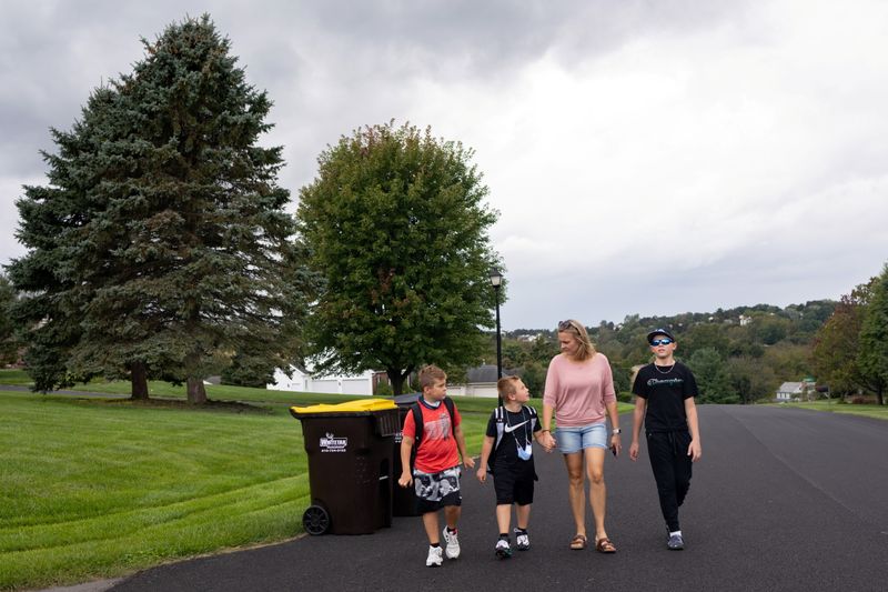 &copy; Reuters. Kelly Toth walks home with her sons (L-R) Nicolas Toth, 8,  Alex Toth, 7, and Christopher Toth, 12, after school in Schnecksville, Pennsylvania, U.S., September 22, 2021. Picture taken September 22, 2021. REUTERS/Hannah Beier