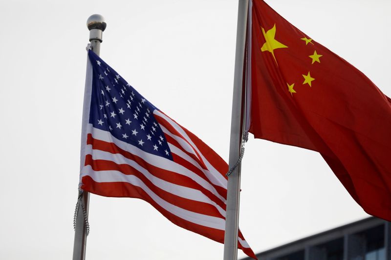 © Reuters. FILE PHOTO: Chinese and U.S. flags flutter outside the building of an American company in Beijing, China January 21, 2021. REUTERS/Tingshu Wang/File Photo