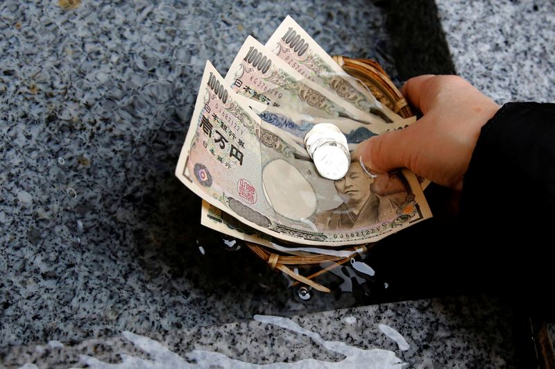 &copy; Reuters. A visitor washes Japanese yen banknotes and coins in water to pray for prosperity at Koami shrine in Tokyo's Nihonbashi business district, Japan, November 13, 2017. REUTERS/Toru Hanai