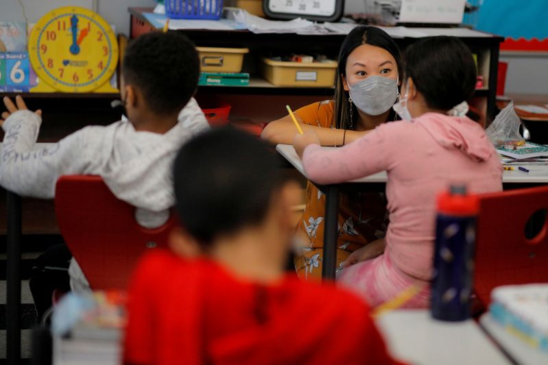 &copy; Reuters. FILE PHOTO: Teacher Mary Yi works with a fourth grade student at the Sokolowski School, where students and teachers are required to wear masks because of the coronavirus disease (COVID-19) pandemic, in Chelsea, Massachusetts, U.S., September 15, 2021. REU