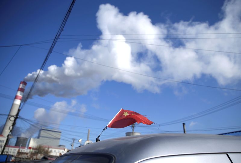 &copy; Reuters. FOTO DE ARCHIVO. Una bandera china flamea sobre las chimeneas de una planta eléctrica alimentada por carbón en Harbin, en la provincia de Heilongjiang, China.  REUTERS/Jason Lee