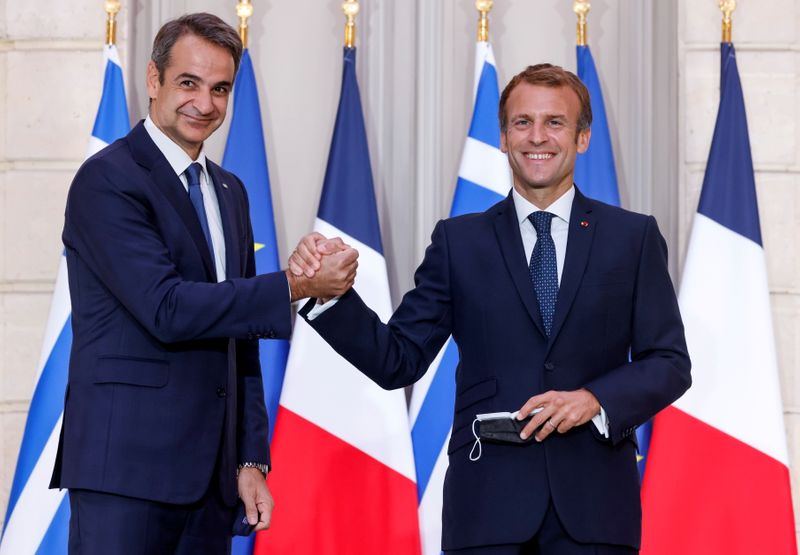 © Reuters. フランスとギリシャは２８日、ギリシャが仏フリゲート艦を約３０億ユーロ（３５億１０００万ドル）で購入する契約を締結した。写真はマクロン仏大統領（右）とギリシャのミツォタキス首相。９月２８日、パリで撮影（２０２１年　代表撮影）