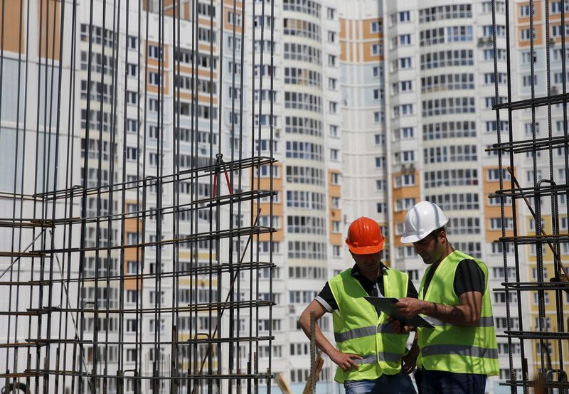 &copy; Reuters. Construction workers talk at Russian real estate developer PIK Group's construction site in Mytischi outside Moscow, Russia, June 3, 2015. REUTERS/Maxim Shemetov
