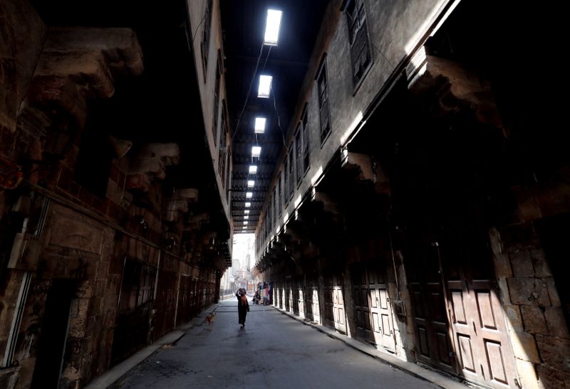 &copy; Reuters. امرأة تسير وسط المحلات المغلقة في شارع الخيامية في القاهرة الإسلامية القديمة يوم 14 سبتمبر أيلول 2021. تصوير: عمرو عبد الله دلش - رويترز