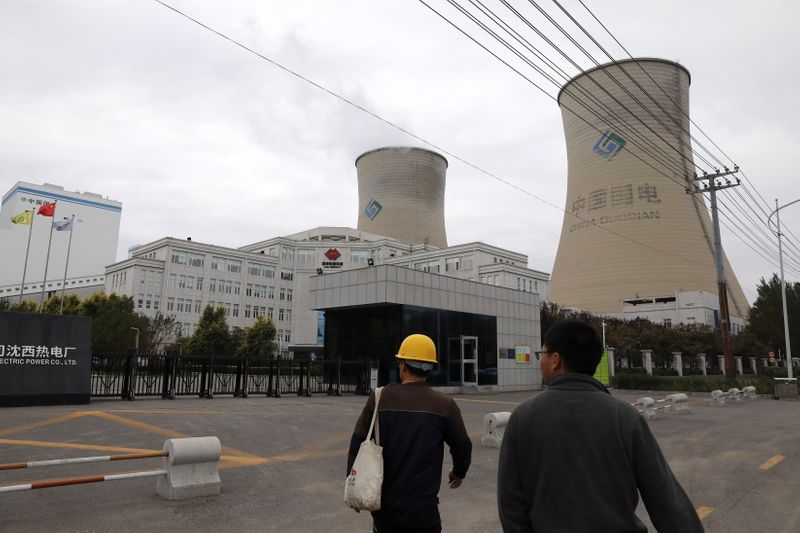 © Reuters. People walk past a China Energy coal-fired power plant in Shenyang, Liaoning province, China September 29, 2021. REUTERS/Tingshu Wang