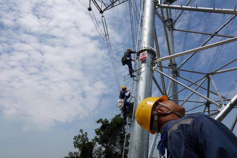 &copy; Reuters. Workers of grid operator China Southern Power Grid climb a transmission tower to inspect power cables in Dongguan, Guangdong province, China May 29, 2018. Picture taken May 29, 2018. REUTERS/Stringer/Files