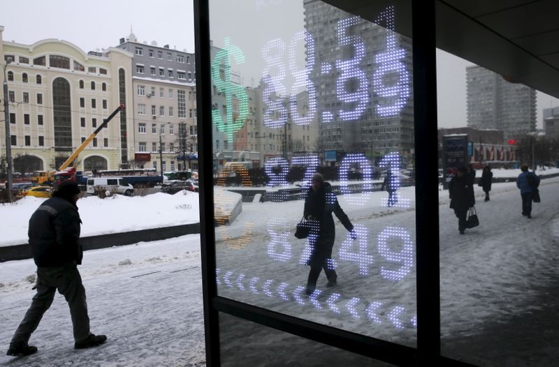 &copy; Reuters. People walk past a board showing the currency exchange rates of the U.S. dollar and the Euro against the rouble in central Moscow, Russia, January 22, 2016. The rouble maintained its slide through record lows on January 21, threatening more hardship for o