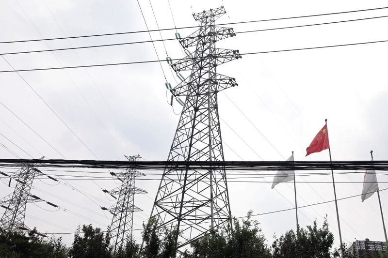 &copy; Reuters. A Chinese flag flutters near power lines and electricity towers in Beijing, China September 28, 2021. REUTERS/Tingshu Wang