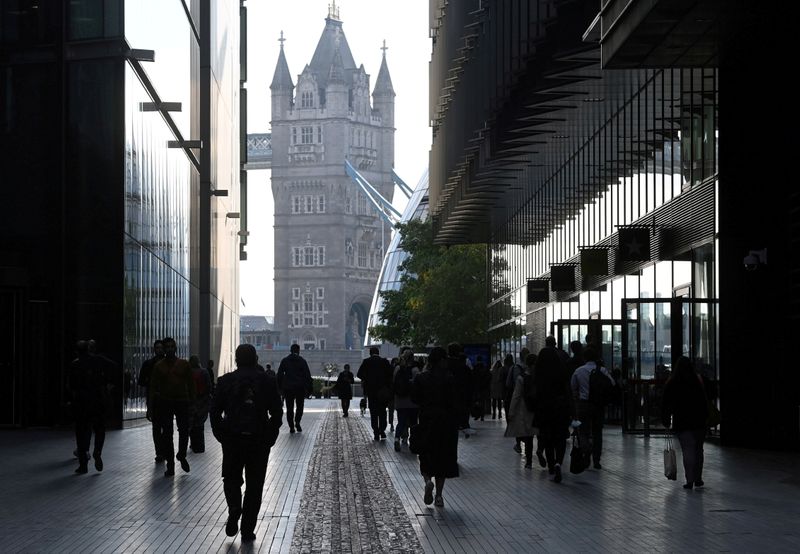 © Reuters. FILE PHOTO: Workers walk towards Tower Bridge in London, Britain, September 15, 2021. REUTERS/Toby Melville/File Photo