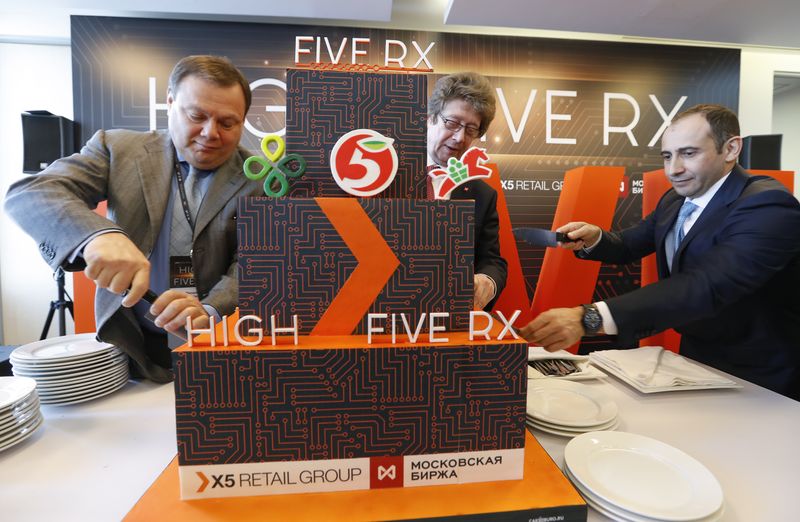 © Reuters. Mikhail Fridman (L), Chairman of Supervisory Board of Alfa Group Consortium and Member of Supervisory Board of ?5 Retail Group, Alexander Afanasiev (C), Chief Executive Officer of Moscow Exchange, and Igor Shekhterman, Chief Executive Officer of ?5 Retail Group, slice a cake during a ceremony as ?5 Retail Group starts trading on Moscow Exchange in the city of Moscow, Russia February 1, 2018. REUTERS/Sergei Karpukhin