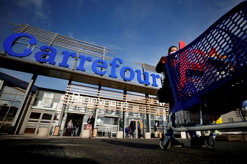 © Reuters. FILE PHOTO: A customer pushes her shopping trolley in front of a Carrefour Hypermarket store in Saint-Herblain near Nantes, France January 15, 2021. REUTERS/Stephane Mahe/File Photo/File Photo