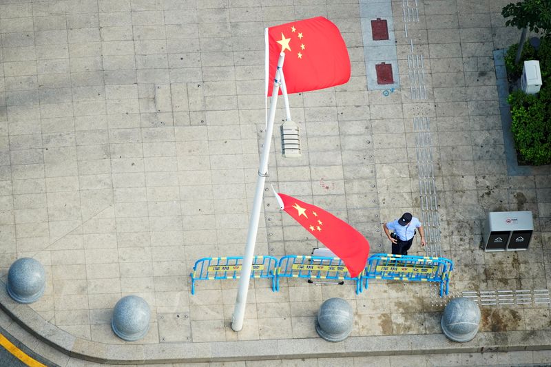 &copy; Reuters. A police officer stands near the Chinese flags and barriers outside the headquarters of China Evergrande Group in Shenzhen, Guangdong province, China, September 30, 2021. REUTERS/Aly Song