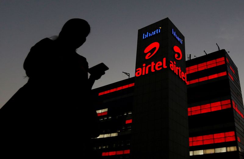 &copy; Reuters. FILE PHOTO: A girl checks her mobile phone as she walks past the Bharti Airtel office building in Gurugram, previously known as Gurgaon, on the outskirts of New Delhi, India April 21, 2016. REUTERS/Adnan Abidi/File Photo