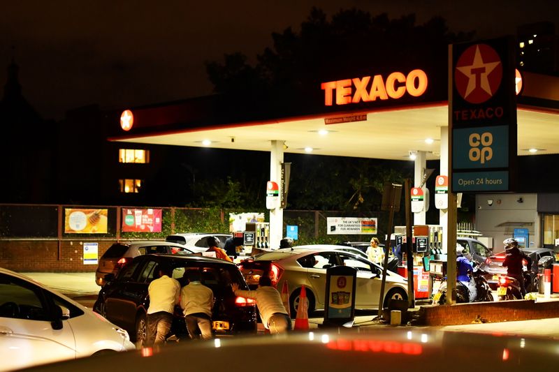 &copy; Reuters. Pessoas empurram carro em fila de veículos diante de posto de combustível no sul de Londres
26/09/2021 REUTERS/Dylan Martinez