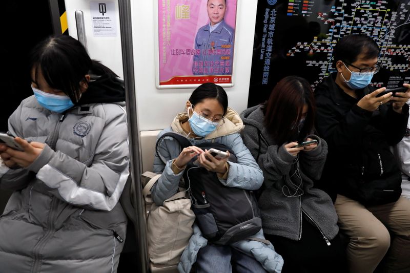 &copy; Reuters. Personas en el metro mirando sus teléfonos, Pekín, China, 25 diciembre 2020.
REUTERS/Tingshu Wang